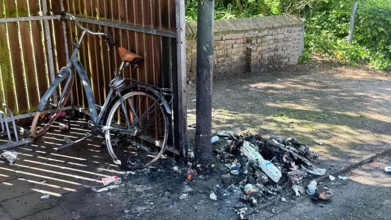 Fiets en stalling raken beschadigd door brandend afval op Sint Wilbertsplein in Bakel